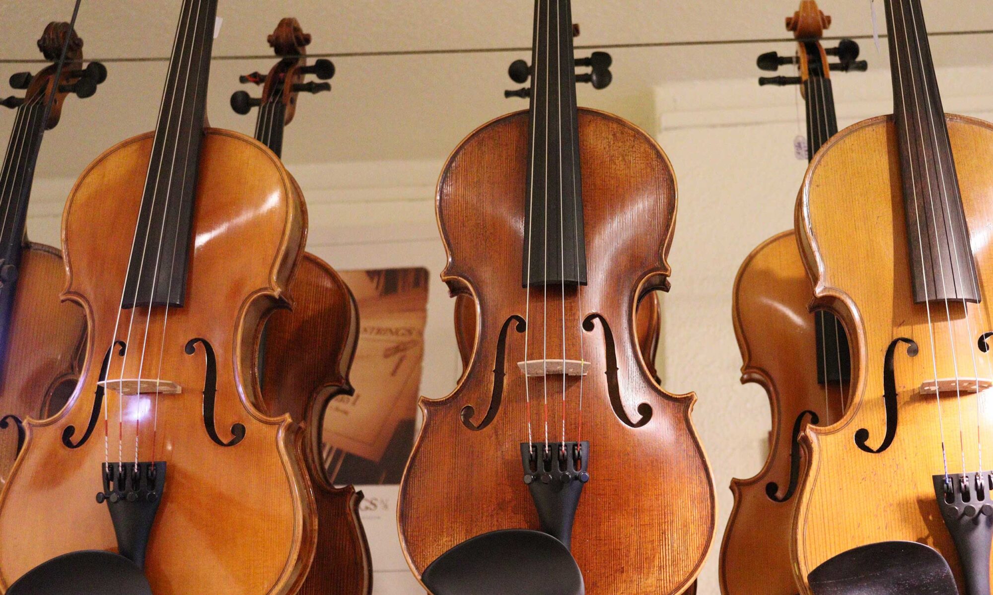Reihe von Geigen hängend in der Frontansicht